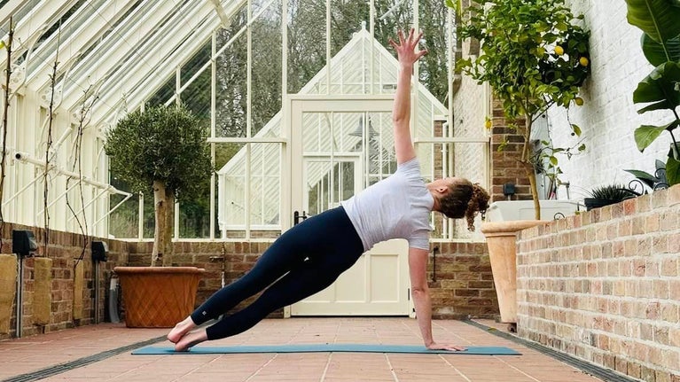 Woman does yoga pose in the newly restored Glasshouses in the Kitchen Garden at Florence Court, County Fermanagh, Northern Ireland